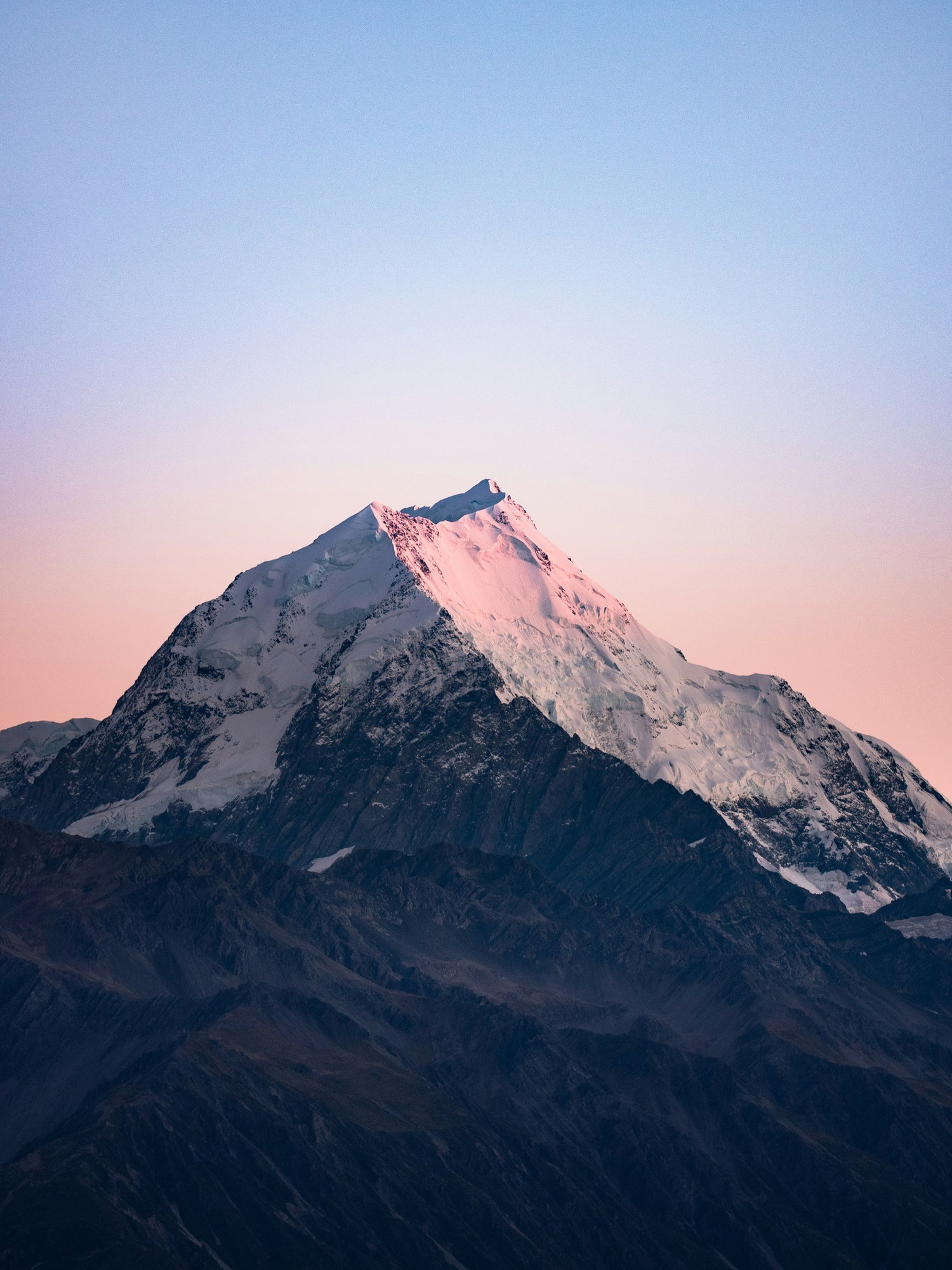Snow-capped mountain peak with a pinkish hue on a clear sky background - VoltMotions Become a Dealer Section